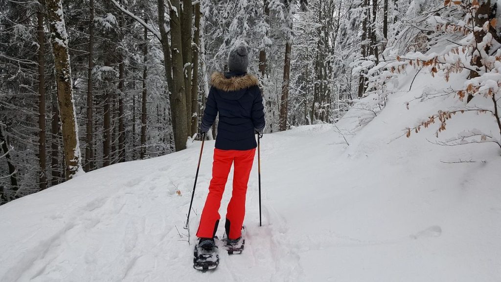 ragazza durante un'escursione sulla neve con le ciaspole